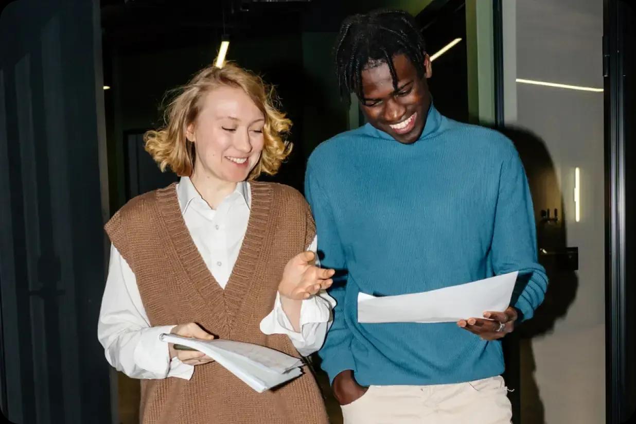A man and woman reviewing a report while walking